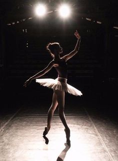 a ballerina is dancing in the dark