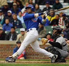 a baseball player is swinging his bat at the ball while people watch from the stands