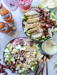 two plates filled with salad and dressing on a table