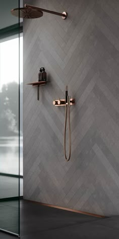 the shower head and handset are shown in this modern bathroom with herringbone tile