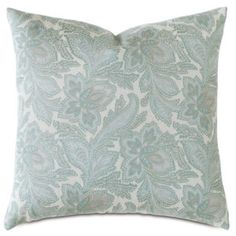 a light blue and white pillow with an intricate design on the front, sitting against a white background