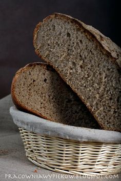 two loaves of bread sitting in a wicker basket on top of a table