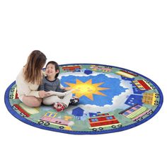 a woman sitting on the floor with a child in front of her, playing with a train rug