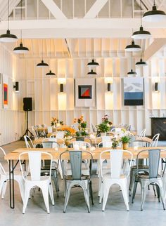 an empty dining room with white chairs and tables