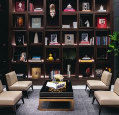 a living room filled with lots of furniture and bookshelves covered in bookcases