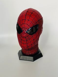 a red spider man mask with black glasses on it's face and eyes closed