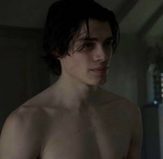 a man without a shirt standing in a room