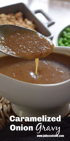 a spoon full of caramelized onion gravy being dipped into a bowl