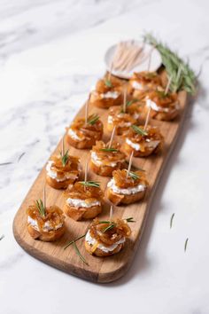 mini pretzels with cream cheese and rosemary sprinkles on a wooden platter