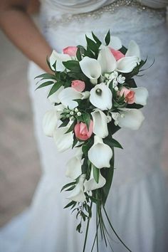 a bride holding a bouquet of white and pink flowers