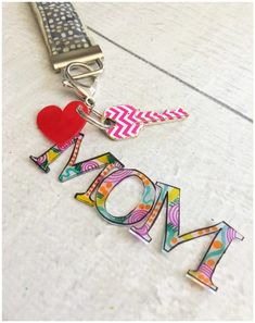 a key chain with the word mom spelled out in colorful letters and a red heart