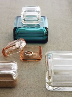 four different colored glass containers sitting on top of a table