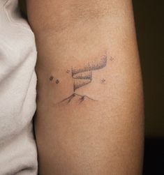 a woman's arm with a tattoo on it that has stars in the sky