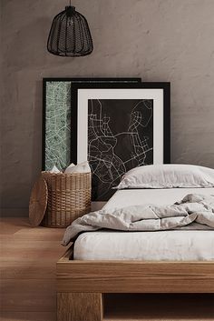 a bed with white sheets and pillows in a room next to a basket on the floor