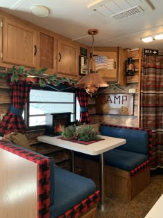 a living area with couches and a table in front of a kitchenette that is decorated for christmas