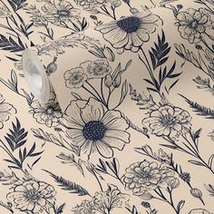 a wallpaper with blue and white floral designs on it's side, next to a roll of toilet paper