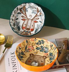 the bowl is decorated with an image of a bear and deer on it, along with two forks