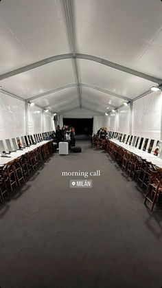 the inside of a white tent with rows of chairs and tables in front of it