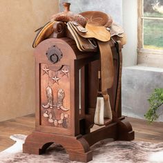 an old fashioned wooden box with saddles and other things on it's side