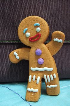 a close up of a ginger figure on a blue surface with a purple suitcase in the background