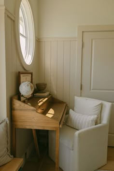 a chair sitting next to a wooden table with a clock on it's side