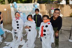 some kids are dressed up as snowmen and one is wearing a penguin costume for halloween