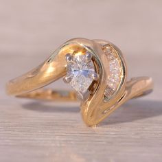 a close up of a gold ring with a diamond on the center and two diamonds in the middle