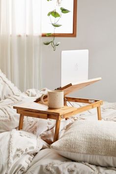 a laptop computer sitting on top of a wooden table next to a cup of coffee