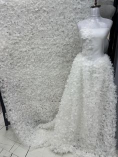 a white dress is on display in front of a mannequin