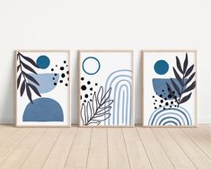 three framed art prints on a wall in an empty room with wood flooring and white walls