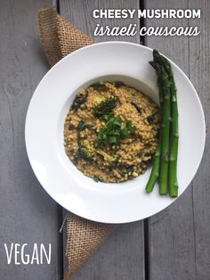 a white plate topped with food next to asparagus