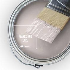 a paint can with a brush in it on top of some purple paint and white background