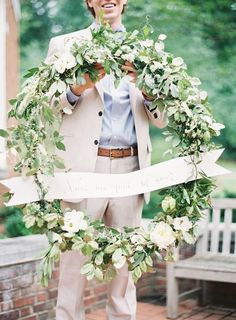 a man in a suit and tie holding a wreath