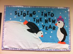 a bulletin board with penguins on it that says sliding into the new year