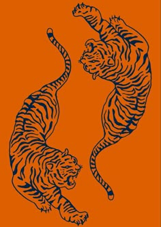 two tigers are playing with each other on an orange background