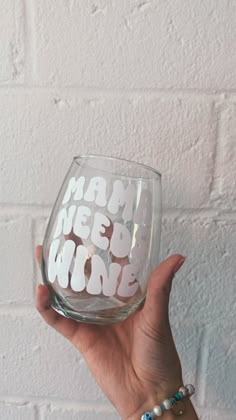 a person holding up a wine glass with words on it