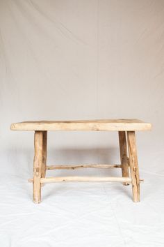 a wooden bench sitting on top of a white sheet