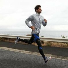 a man running down the road by the ocean