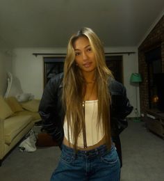 a woman standing in a living room next to a couch