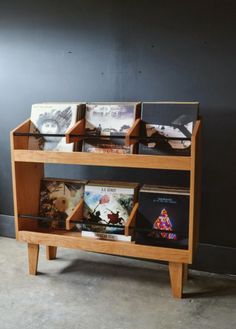 a wooden book shelf with several books on it and two shelves holding various magazines,