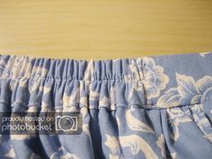 the bottom of a blue and white flowered skirt with ruffles on it