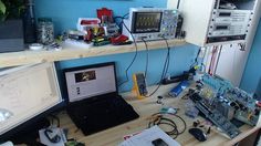 a laptop computer sitting on top of a desk next to a monitor and other electronic equipment