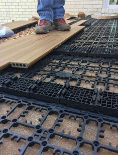 a man standing on top of a wooden floor next to metal grate grids