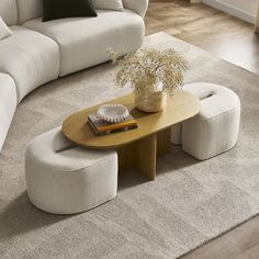 a living room with a white couch and coffee table on the floor next to a gray rug