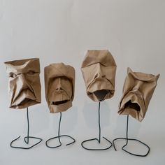 three sculptures made out of brown paper and wire