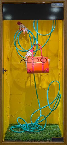 a yellow wall with blue and pink cords attached to it, in front of a wooden frame