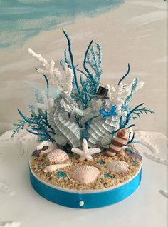 a blue and white cake with sea shells on it