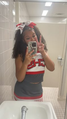 a woman taking a selfie in the bathroom with her cell phone up to her ear