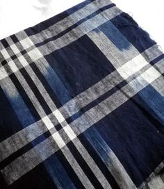 a blue and white checkered blanket laying on top of a bed