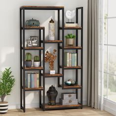 a book shelf with many books on top of it next to a potted plant